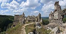 "Photographies des ruines, situées sur un promontoire dominant des vallées boisées."