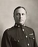 an image of a white male in his military uniform with no hat. Military style ribbons are clearly visible.