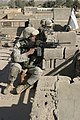 A U.S. Marine and Iraqi Army soldiers watch over the surrounding streets from a rooftop in Karabilah, Iraq.