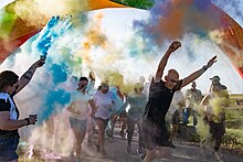 U.S. Air Force airmen run through the starting line of the Pride Month color run at Altus Air Force base, Oklahoma, June 2022.