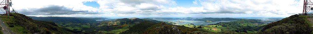 Pohled východně od vrcholu Mount Cargill; přístav je v pozadí, vpravo; za přístavem je poloostrov Otago Peninsula; zcela vlevo je část TV věže