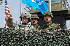 Un officier américain et deux militaires sud-coréens surveillant la DMZ.