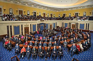 the full senate seated at their desks with additional staff in the gallery