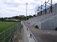 Tribune du stade à droite de la pelouse du stade.