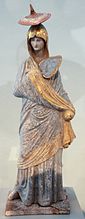 Unha dama en azul ("Lady in Blue"). Véxase estatuiña similar no Louvre Arquivado 26 de maio de 2021 en Wayback Machine. Estatuiña de Tanagra, 335-300. Terracota pintada e dourada, H. 34 cm. Museo de Altes