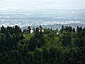 Blick vom Aussichtsturm des Großen Feldbergs zum Gipfel des Kleinen Feldbergs, dahinter der Fernmeldeturm auf dem Atzelberg und der Ort Bremthal sowie am Horizont Wiesbaden