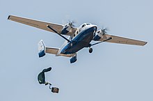 A parachuted bundle soars out of the back of a C-145 Skytruck during an air-drop mission over the Eglin Air Force Base range.