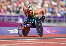 A photo of Kurt Fearnley, in a wheelchair, racing on a track