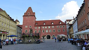 Blick von Osten über den Haidplatz (2017) und Blick von Westen über den Haidplatz (2014) auf die Arch (links), Goldenes Kreuz (rechts) und auf Neue Waag und Thon-Dittmer-Palais (links) In der Platzmitte der Justistiabrunnen