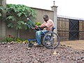 Un utente di sedia a rotelle Leveraged Freedom in Kenya. La sedia è stata progettata per essere economica e utilizzabile sulle strade sconnesse comuni nei paesi in via di sviluppo.