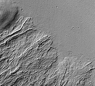 Image shows both young and old lava flows from the base of Olympus Mons. The flat plain is the younger flow. The older flow has channels with levees along their edges. The presence of levees is quite common in many lava flows.