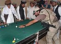 US special forces playing a game of pool with local villagers in August 2002