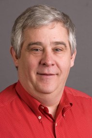 Middle-aged man with grey hair in a red polo shirt