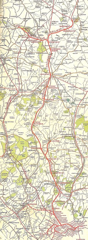 Map of a long railway line, ending at one end in a fork to two termini, and at the other end in a loop with a number of closely packed stations.