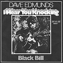 Single cover sleeve with black & white photo of Edmunds playing an acoustic guitar