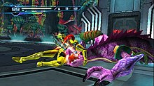 A person in a powered armor grabs a chameleon-like creature. Atop the screen are 2D icons which indicates the health and ammo of the player.