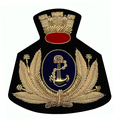 Fregio da berretto rigido per ammiraglio di squadra, si noti lo sfondo rosso sotto la torre e quello blu nell'ovale dell'ancoretta