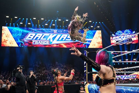 LYON, FRANCE - MAY 4: Kairi Sane dives off the top rope to the outside on Bianca Belair during Backlash France at LDLC Arena on May 4, 2024 in Lyon, France. (Photo by WWE/Getty Images)