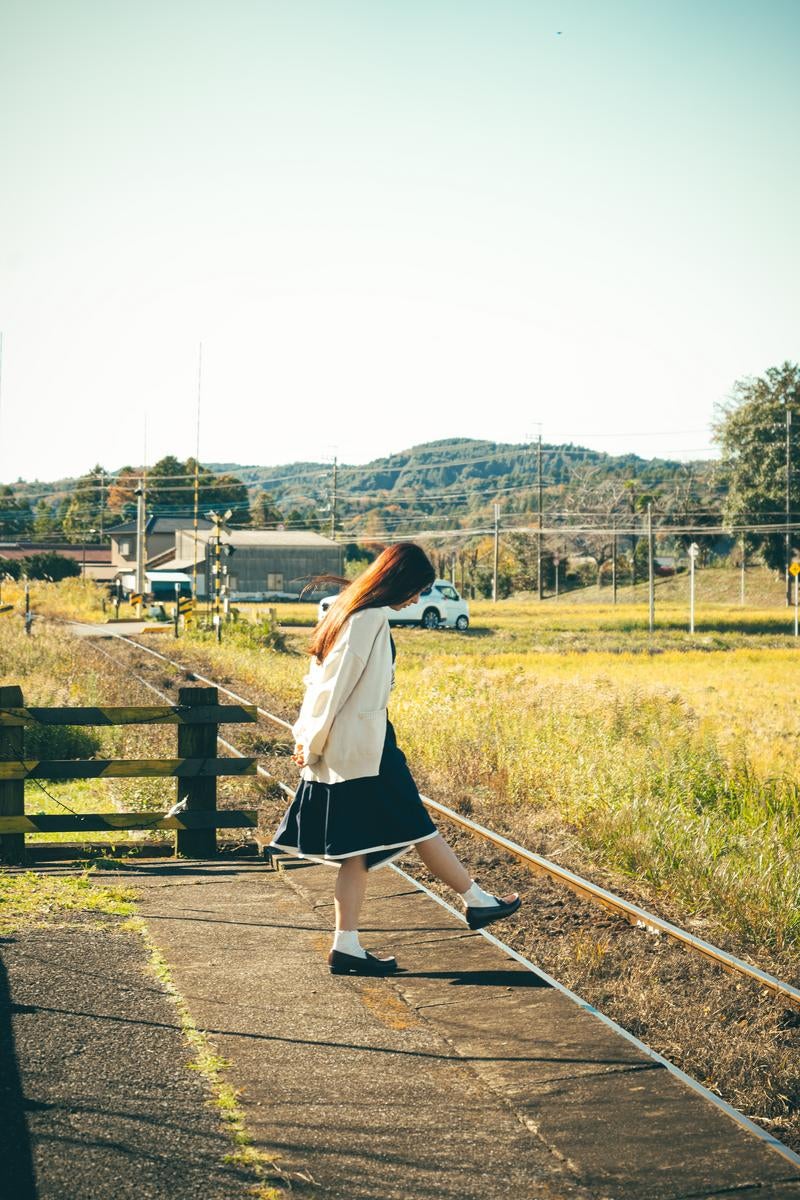 のどかな田舎町の駅のホームと女性の写真