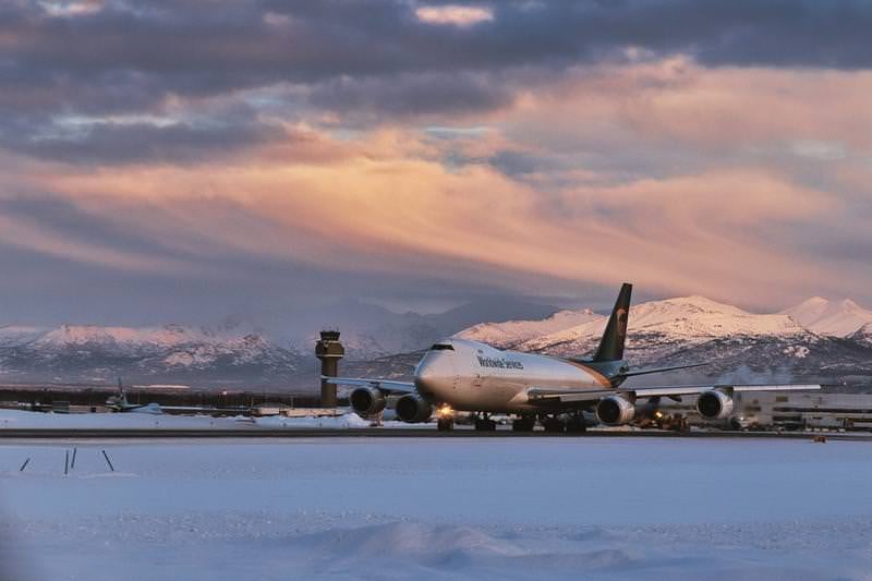 冬の夕暮れに映えるUPS貨物機と雪景色の写真