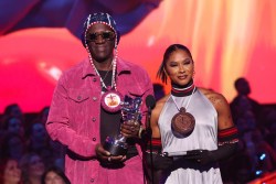 ELMONT, NEW YORK - SEPTEMBER 11: (L-R) Flavor Flav and Jordan Chiles speak on stage during the 2024 MTV Video Music Awards at UBS Arena on September 11, 2024 in Elmont, New York.  (Photo by Mike Coppola/Getty Images for MTV)