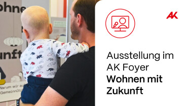 Ein Vater mit Kind auf dem Arm, beide schauen auf eine Schautafel der Ausstellung „Wohnen mit Zukunft“