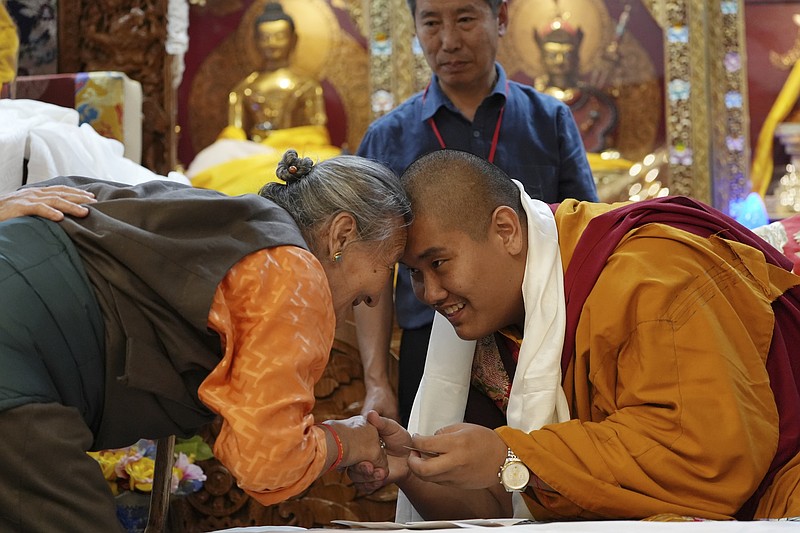 U.S.-born Buddhist lama, Jalue Dorje, right, and a member of the Minnesota Tibetan community bow and touch foreheads in a traditional Tibetan greeting at his 18th birthday and enthronement ceremony in Isanti, Minn., on Saturday, Nov. 9, 2024. (AP Photo/Luis Andres Henao)