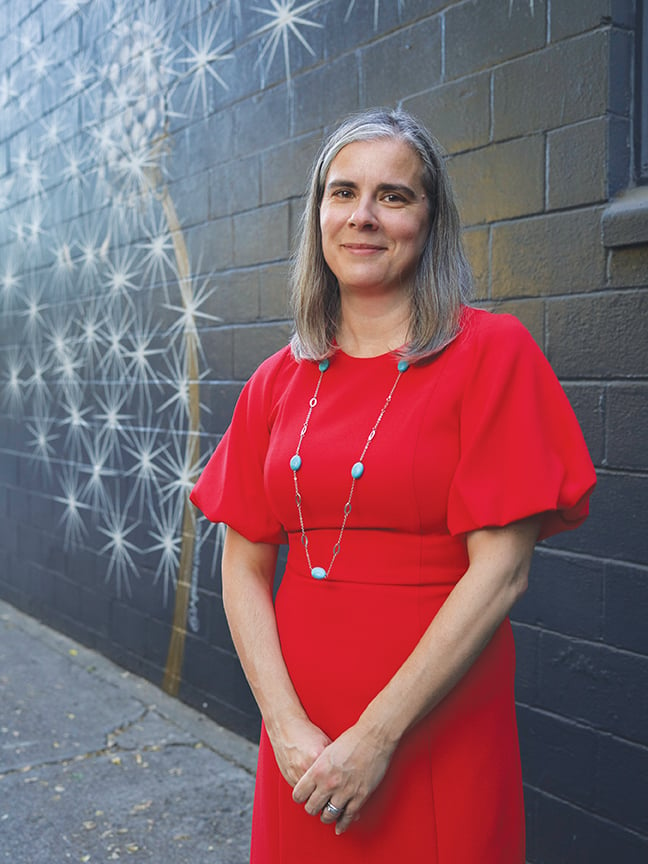 Megan Van Voorhis in front of The Wishing Wall mural by Sacramento artist Maren Conrad