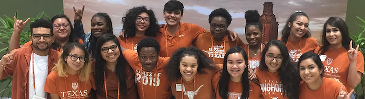 Smiling group of UT students wearing burnt orange shirts