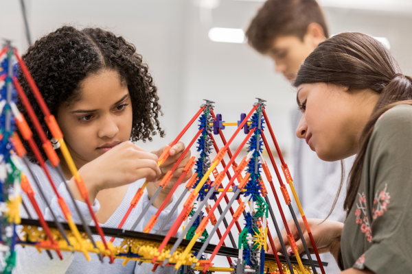 Two students building a model bridge in school