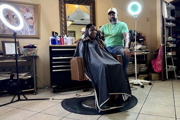 Hair stylist Garrett Milton, 66, tends to a client at his parlor in Fort Valley, the Hidden Image. Milton believes Kamala Harris will win November's presidential election. "You’re getting a Black female running for a Democratic presidency. … I think Black women are going to stand up and fight” for her, he said. (Joe Kovac Jr. / AJC)