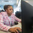 Destiny Smith works on her job application in a mobile career center at a job fair hosted by Goodwill Career Center in Atlanta in July. The number of advertised job openings is down, but it's still about the same level as it was pre-pandemic. (Ziyu Julian Zhu / AJC)