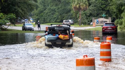 A truck drives through a flooded road on Bradley Blvd on Monday, August 12, 2024 in Savannah, GA. (AJC Photo/Katelyn Myrick)