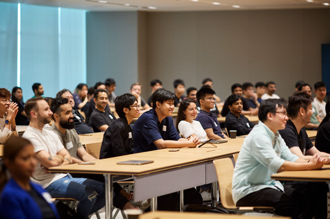 展示一群開發者坐在 Apple Developer Center。