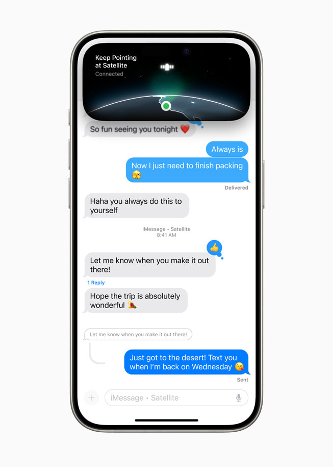 iPhone 15 Pro menampilkan percakapan teks di iMessage dengan gambar satelit dan frasa “Tetap Menunjuk ke Satelit… Terhubung” di Dynamic Island.