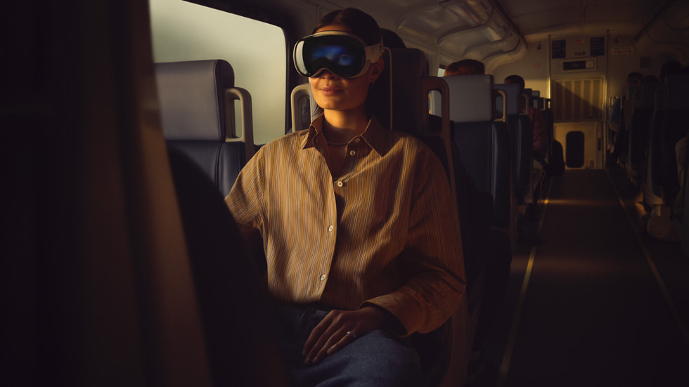 Eine Person in einem Zug, die eine Apple Vision Pro trägt.