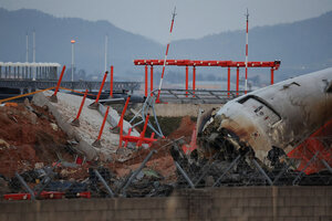 韓国の務安国際空港で2024年12月30日、コンクリートの構造物の近くに済州航空の旅客機の残骸があった=ロイター