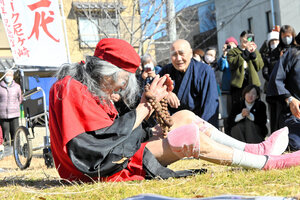 踊りの終わりに車いすから地面に降りて、祈りのポーズをするギリヤーク尼ケ崎さん=2025年1月18日午後1時32分、神戸市長田区、原野百々恵撮影