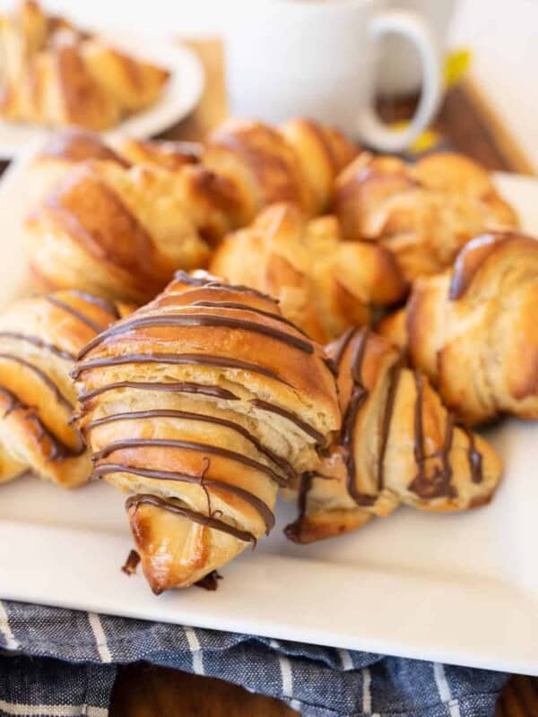 three kinds of croissants on a white plate with tea