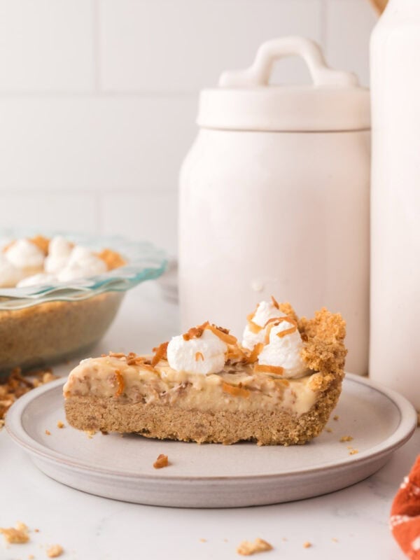 slice of coconut cream pie with dollops of cream on top.