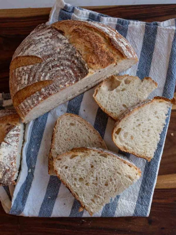 sourdough loaf cut into halves with some slices.