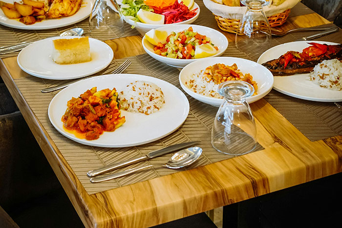 Restaurant table with cold food, dishes, and glasses, highlighting a customer and staff tipping issue.