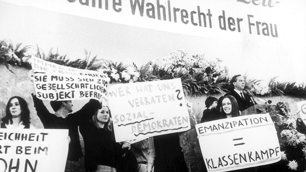 Angehörige des "Aktionsrates zur Emanzipation der Frau" des Sozialistischen Deutschen Studentenbundes (SDS) stürmen am 12.10.1968 während einer SPD-Veranstaltung in der Frankfurter Paulskirche zum 50. Jahrestag des Frauenwahlrechts mit Transparenten das Rednerpodium. Die Studentinnen warfen der derzeitigen offiziellen Gleichberechtigungspolitik vor, die gesellschaftsbedingte Ungleichbehandlung der Frauen zu verschleiern. | Bild: picture-alliance / dpa | Manfred Rehm