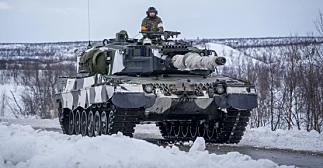 En finsk stridsvogn av typen Leopard 2 krysser grensen mellom Finland og Norge tidligere i vinter. Norge har bestilt 54 tilsvarende stridsvogner fra den tyske produsenten KNDS Deutschland, og tirsdag ble det kjent at 37 av kjøretøyene vil bli montert hos Ritek i Norge. Foto: Heiko Junge / NTB