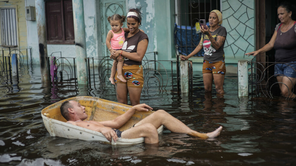 VÅTT: En mann flyter ned gata i en boks i Batabano i Cuba, etter at Helene oversvømte da orkanen passerte. På daværende tidspunkt var orkanen klassifisert i en lanvere kategori. Foto: Ramon Espinosa / AP Photo