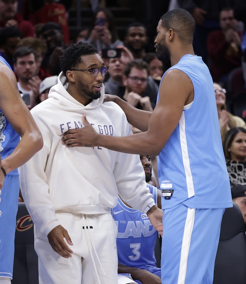 Cavaliers guard Donovan Mitchell, in street clothes, and Tristan Thompson celebrate