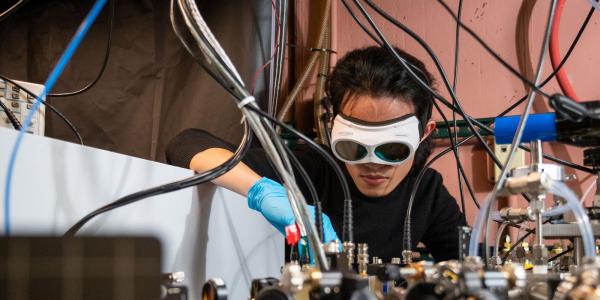 Qizhong Liang, a PhD candidate in JILA and the Department of Physics, demonstrates how the laser-based breathalyzer works, in the Ye lab at JILA.