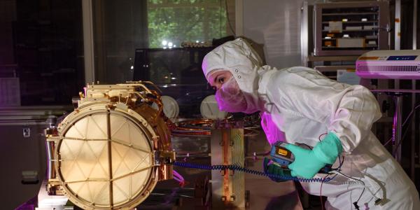 An engineer ground tests Europa Clipper’s dust analyzer.