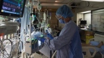 A file photo of a registered nurse tending to a patient in a COVID-19 positive room on April 21, 2020. (Source:THE CANADIAN PRESS/Jonathan Hayward)