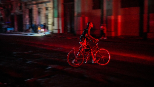 A resident walks his bicycle during a blackout following the failure of a major power plant in Havana, Cuba, Sunday, Oct. 20, 2024. (AP Photo/Ramon Espinosa)